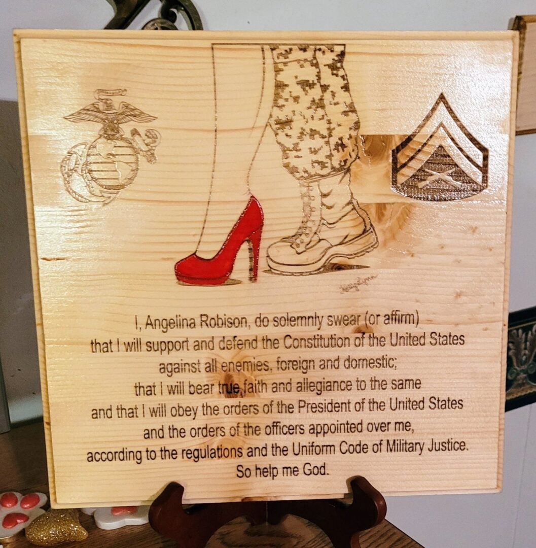 Kelly McCook Series Enlistment Oath Plaque with an engraving of a person wearing high heels and combat boots, juxtaposed with military and patriotic symbols, alongside an oath of allegiance.