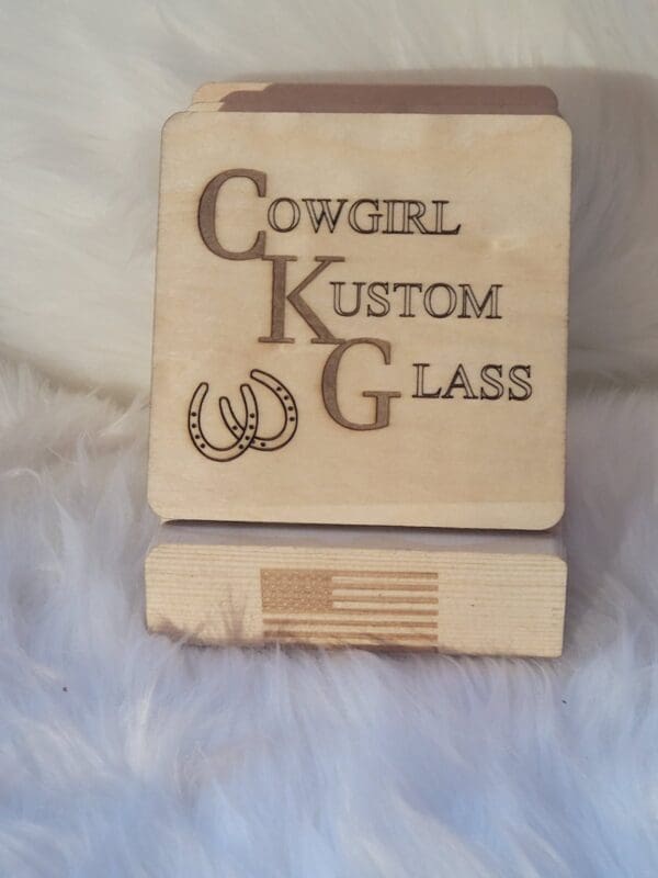 A wooden coaster with the words cowgirl kustom glass on it.