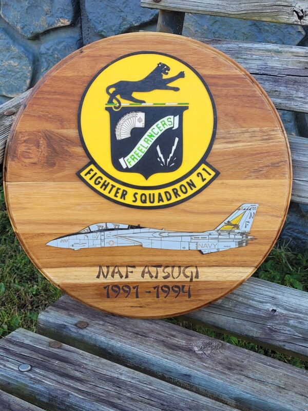 A wooden plaque with the fighter squadron 2 1 insignia on it.