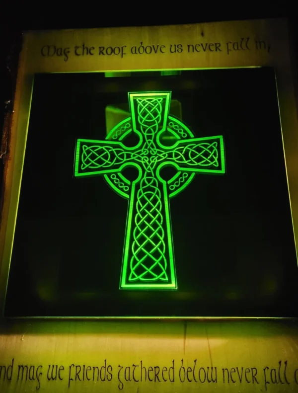 A cross lit up in green on the wall.