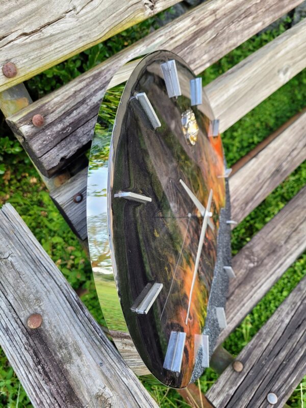 A clock is sitting on top of a wooden bench.