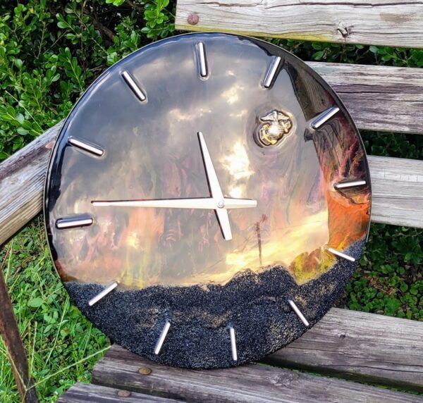 A Iwo Jima Resin Clock with a reflective surface and textured lower edge, sitting on a wooden surface, displaying the time as approximately 4:00.
