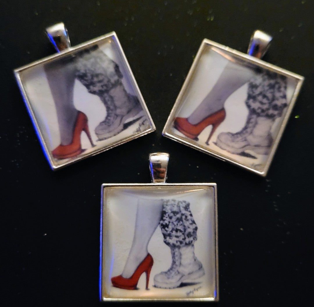 Three Kelly McCook Design necklaces featuring black and white illustrations of legs in different stylish red-heeled shoes against a black background.