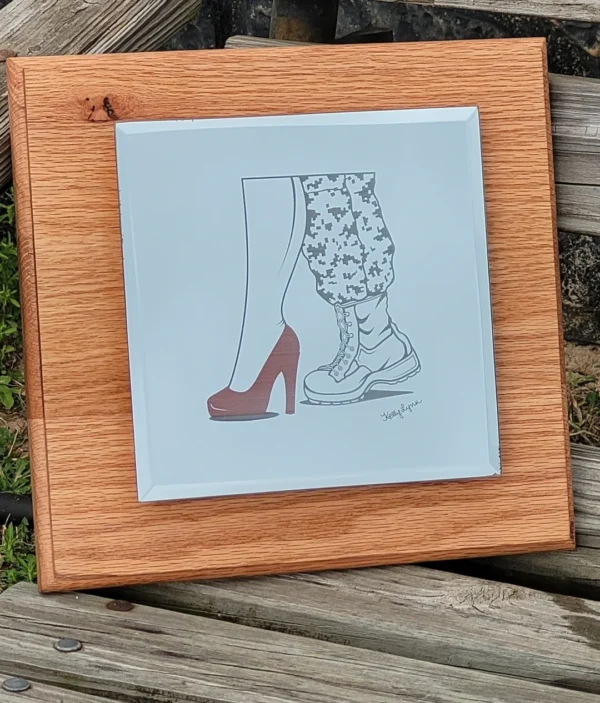 Custom Engraved Mirrors of two different styled legs, one wearing a red high heel and the other a sneaker with patterned shorts, framed in light wood on a wooden surface.