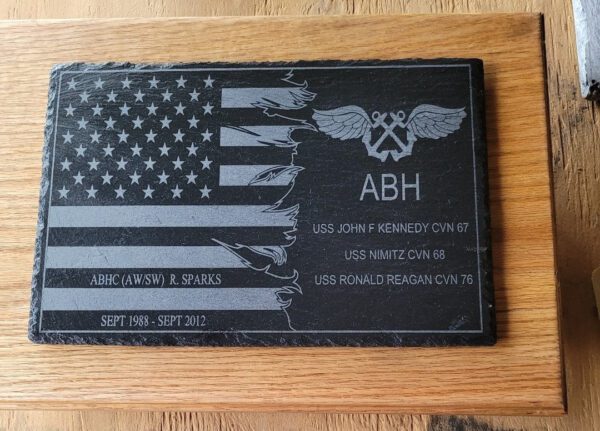 A black plaque with a distressed American flag design and text commemorating service on Custom Flags from Sept 1998 - Sept 2012.