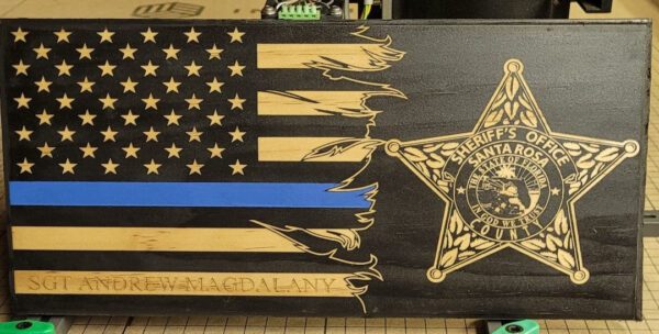 A wooden flag with the words " law enforcement " and an image of a police officer.