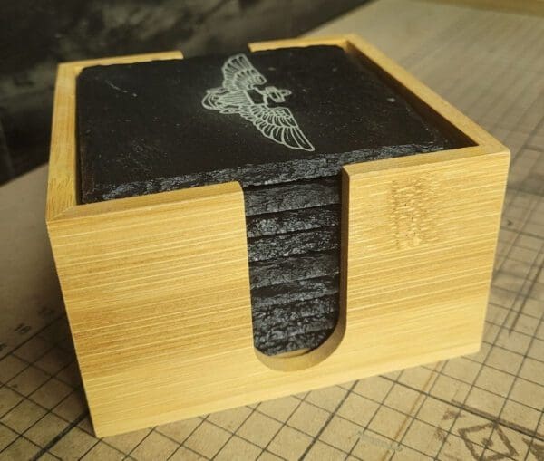 A wooden box with some black coasters on top of it