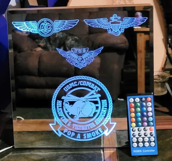 Custom Engraved Mirrors displaying military emblems including a usmc combat helicopter squadron symbol, with a remote control in front.