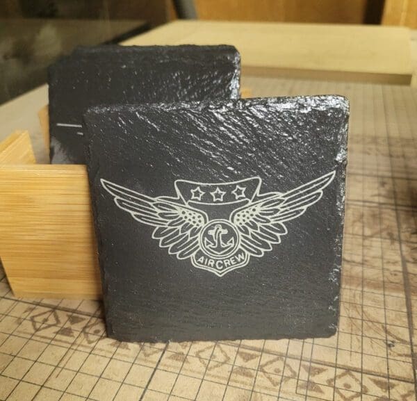 A black stone coaster with an eagle and stars on it.