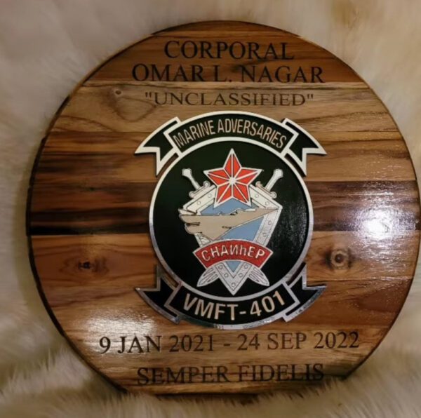 A wooden plaque with the name of an officer and date.