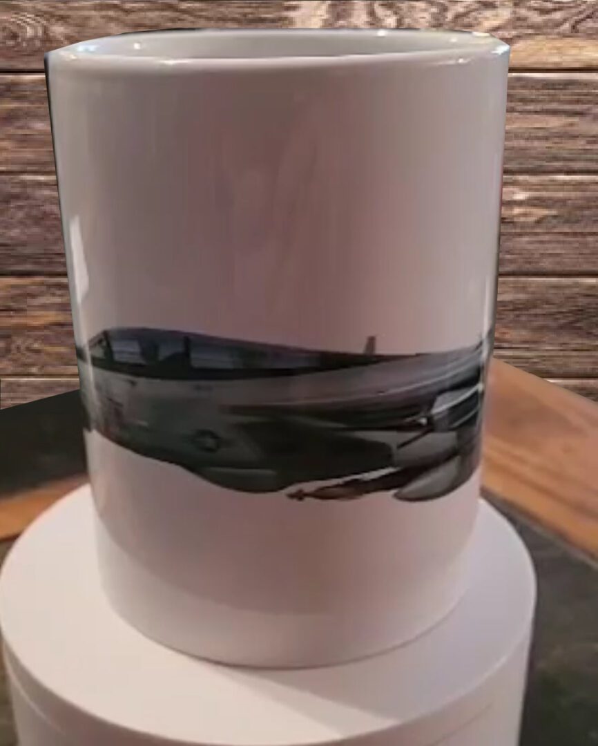 Mads Bangsø Collection coffee mug with a panoramic black and white photograph of a cityscape wrapped around it, placed on a wooden surface.
