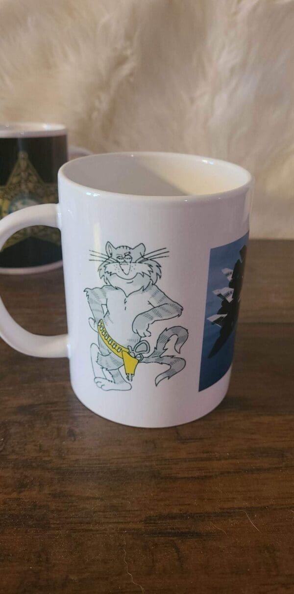 A white coffee mug with a cat on it.