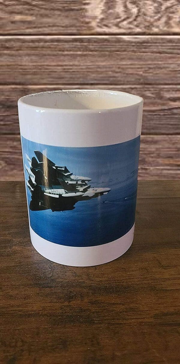 A coffee mug with an image of a boat on the water.