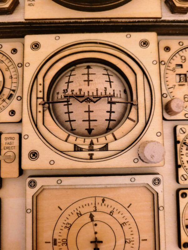 Close-up of a Legend Plaques featuring a circular altimeter with crosshair markings, surrounded by multiple dials and gauges.