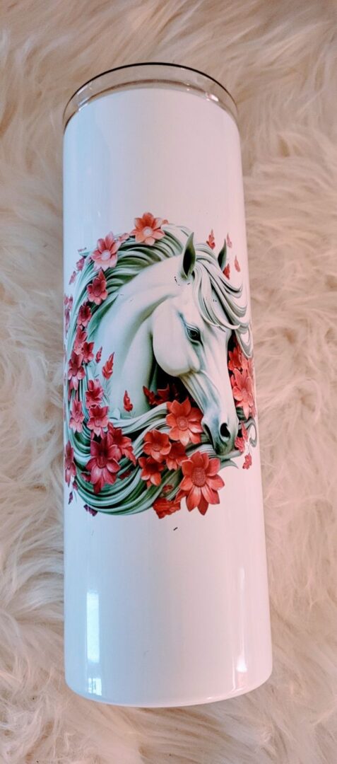 A white horse with red flowers on it's face.