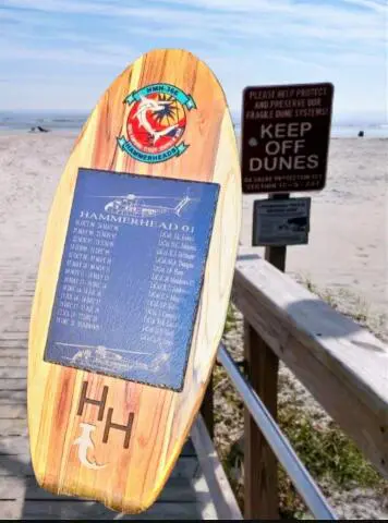 A surfboard with the names of surfers on it.
